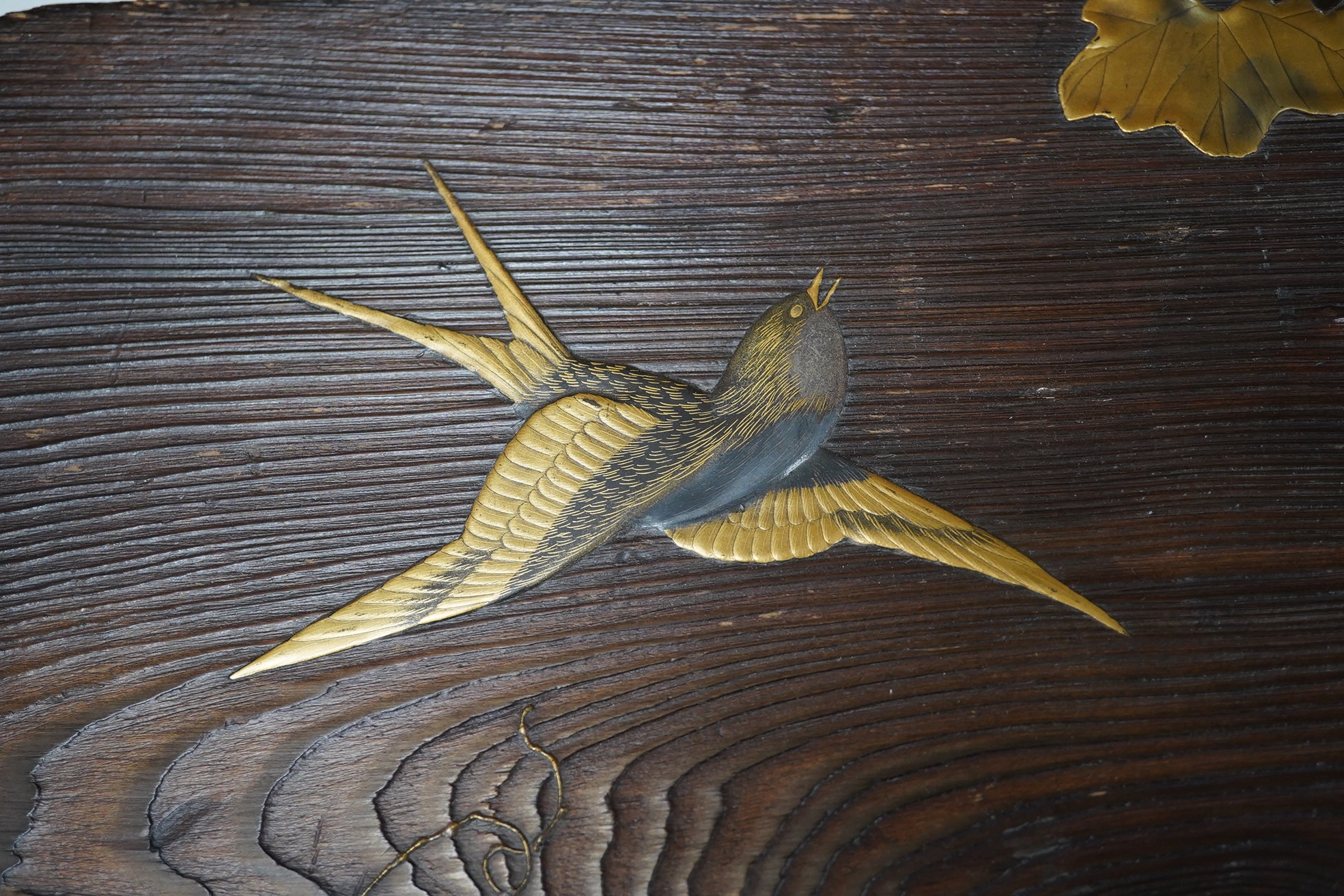 A 19th century Japanese grained wood and lacquer work panel, with mother-of-pearl flower buds, 29 x 55cm. Condition fair to good, minor chips and scratches to the wood.